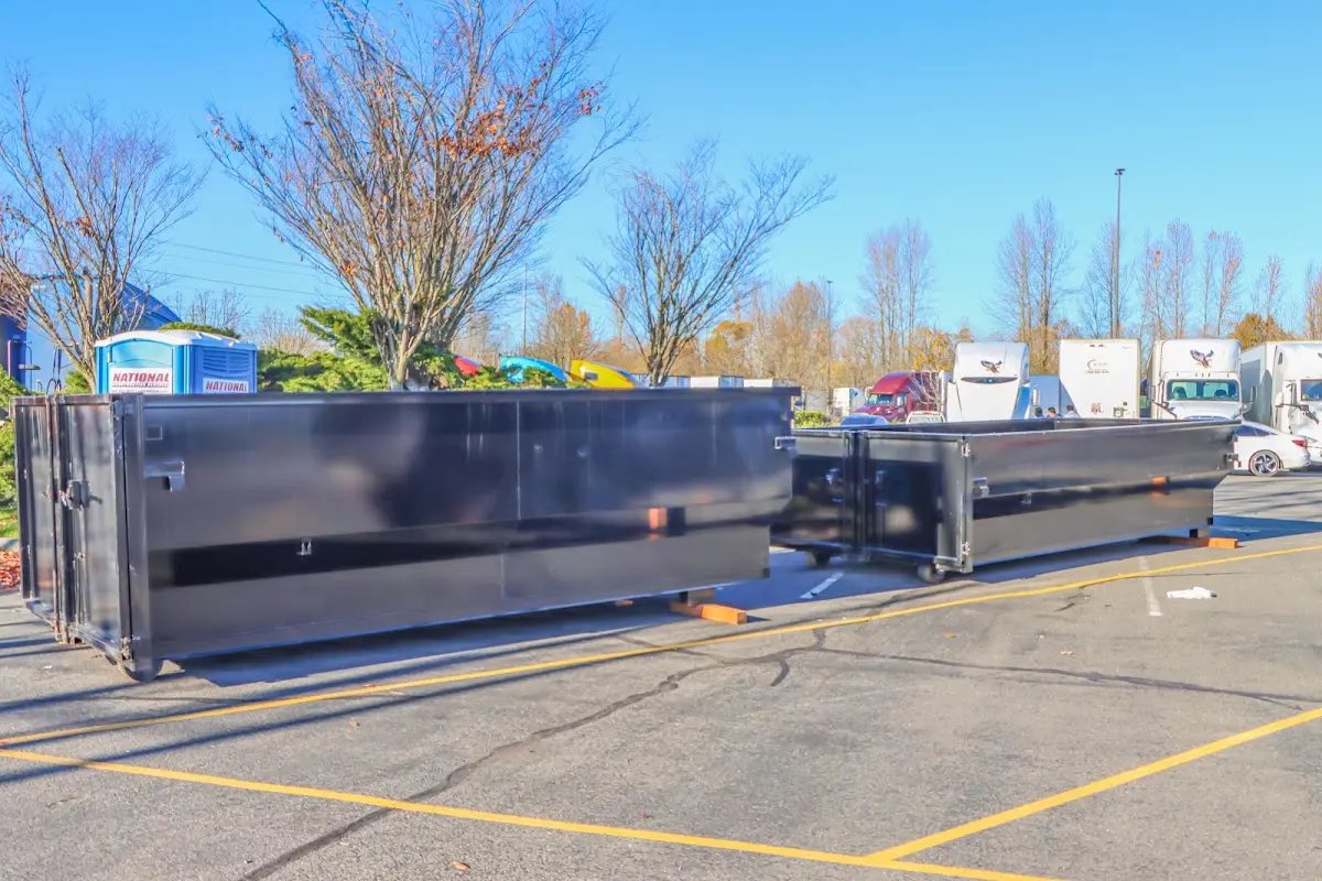 Professional dumpster rental service with roll-off container on residential driveway in Kalkaska